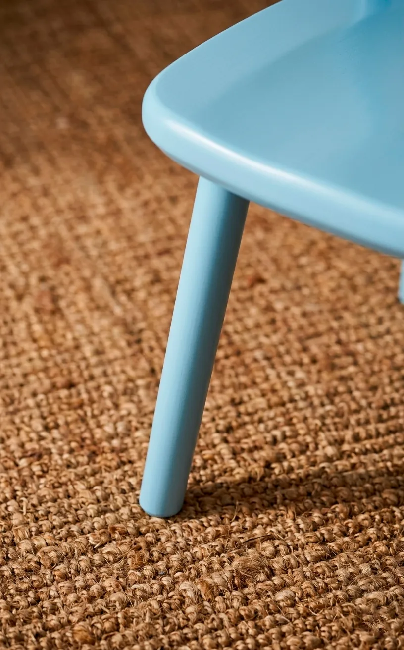 Detail of a smooth pastel blue paint finish on a wooden furniture piece.