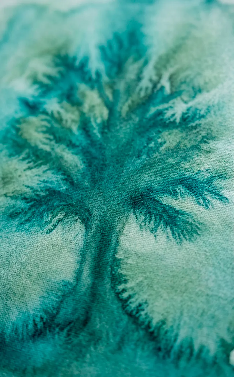 Close-up of watercolor canvas texture showing bleeding teal and sage green paint.