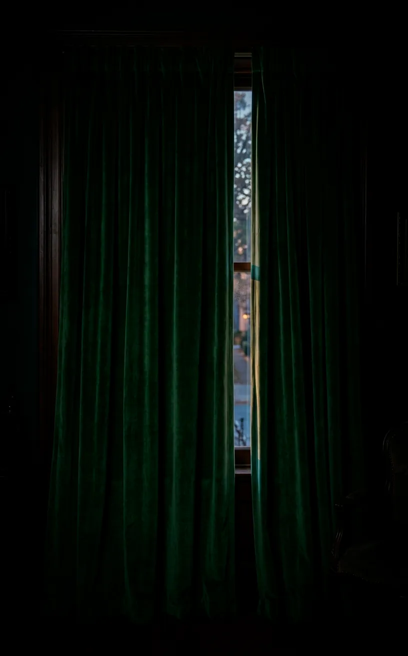 Floor-to-ceiling forest green velvet drapes in a moody mid-century bedroom.