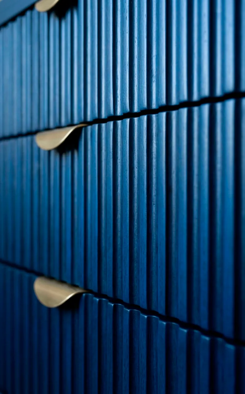 Detailed texture of ribbed fluted drawers on a blue dresser.