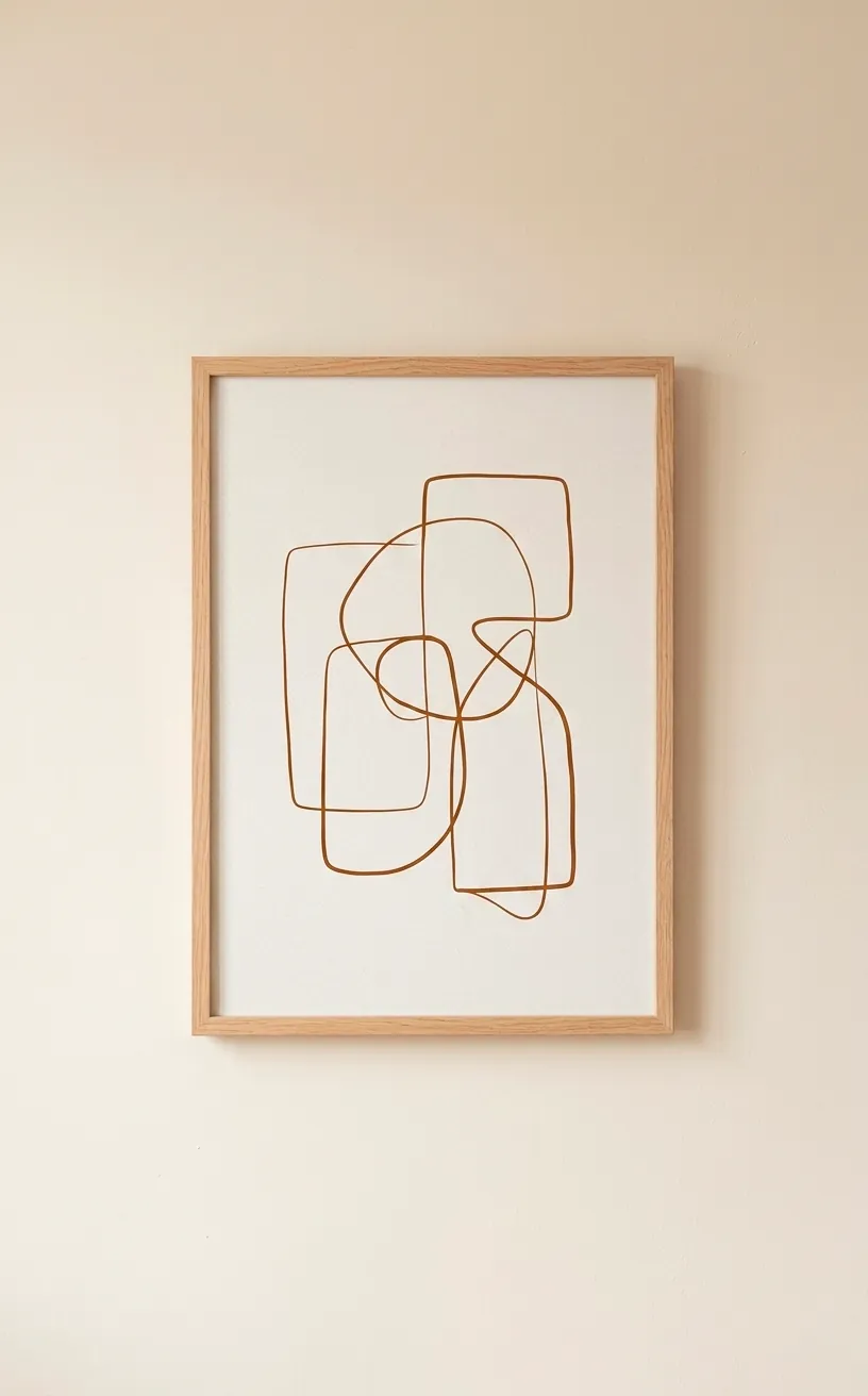 Minimalist gingerbread brown line art print hanging in a simple frame on a cream wall.