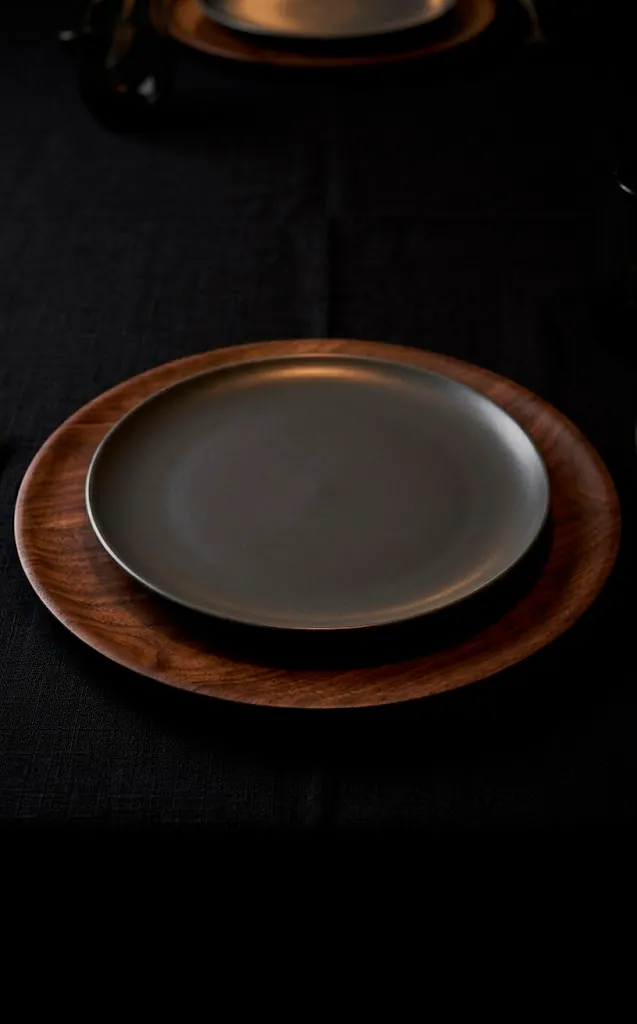 Dark walnut wood charger plate on a black Thanksgiving table.