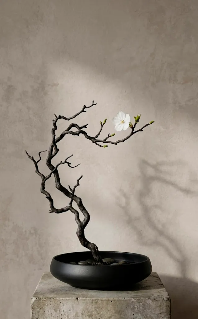 Minimalist Ikebana floral arrangement with a single branch in a black bowl.